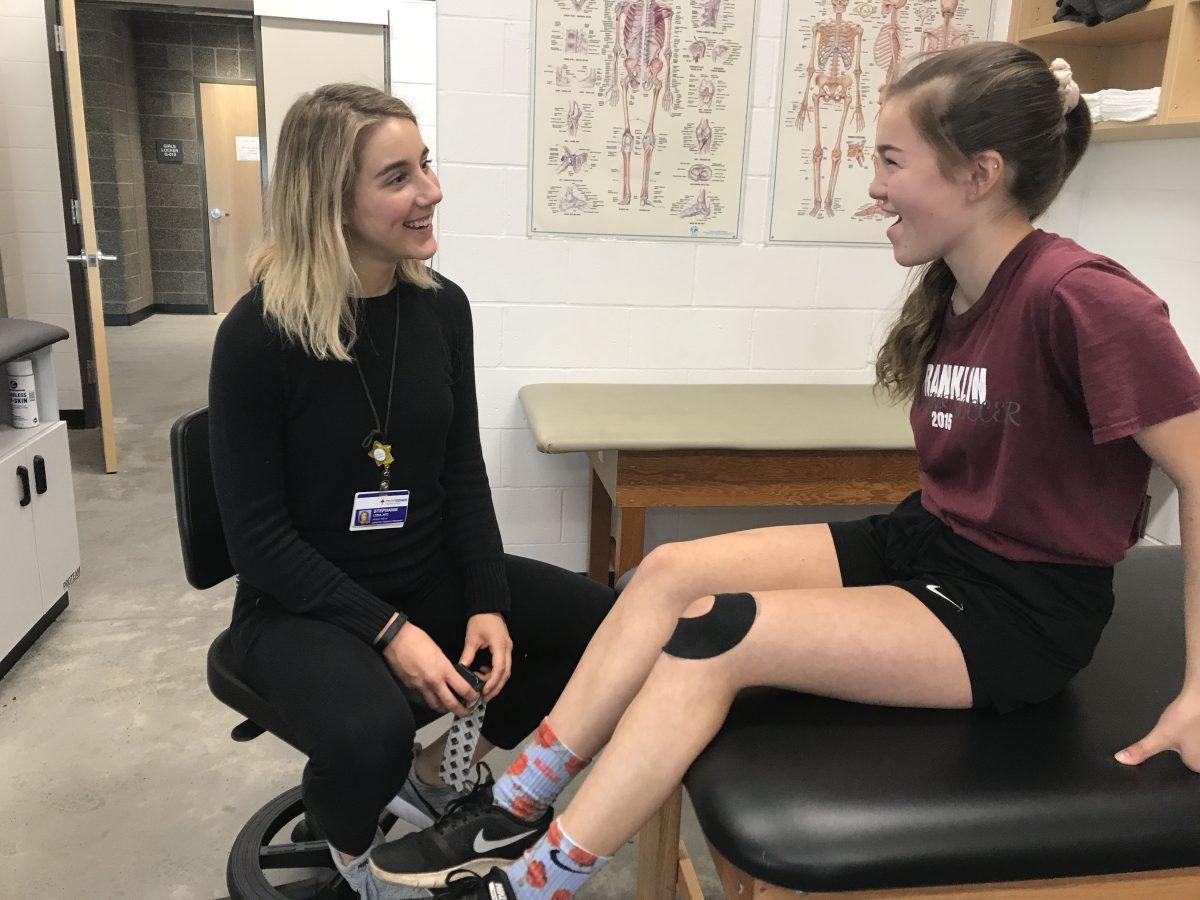 Stephanie Lyda, Franklin’s athletic trainer, treats an athlete in the training center. Lyda is in her second year as Franklin’s athletic trainer and enjoys helping athletes recover from injuries. Photo by Annika Mayne.