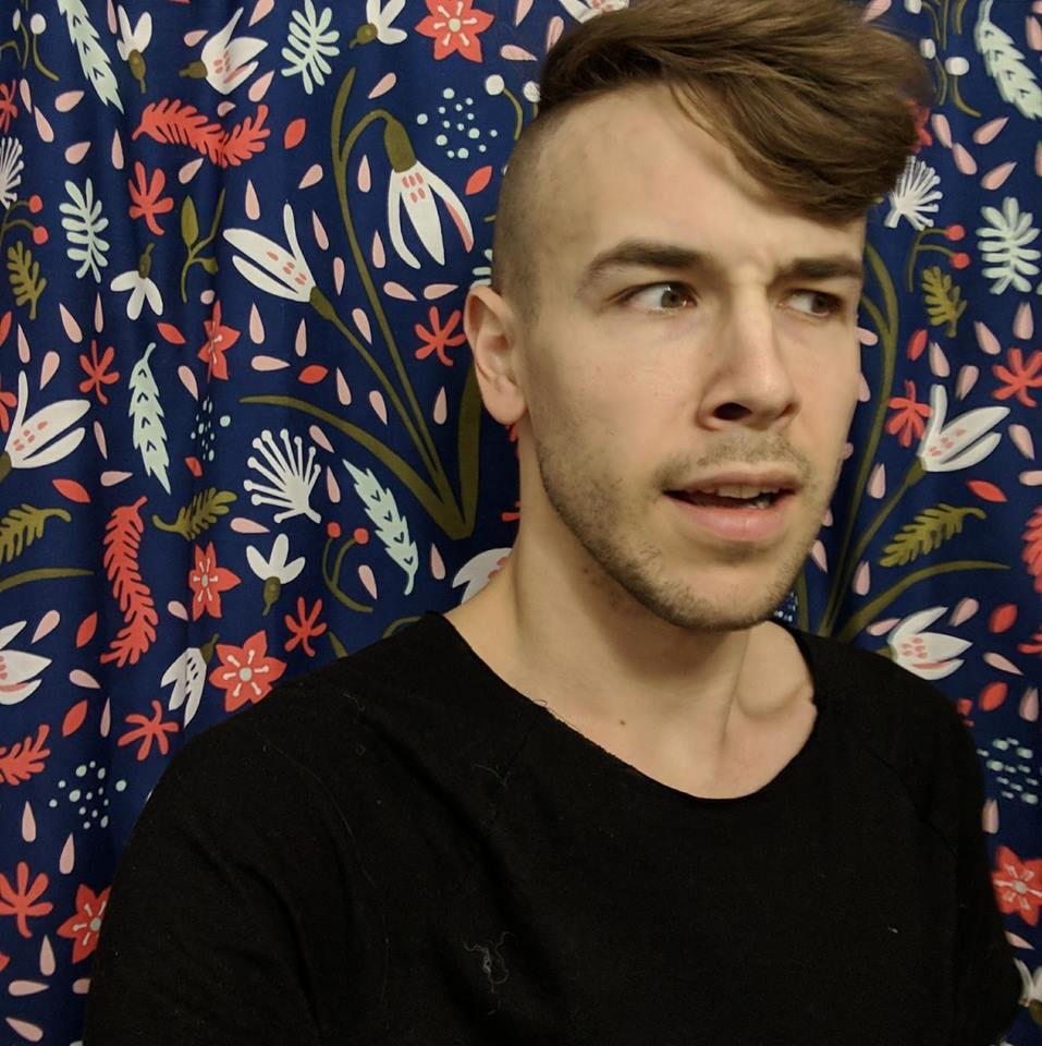 Jordan McFarland poses in front of a colorful backdrop. He started working in coffee when he was 19. Photo by Jordan MacFarland.