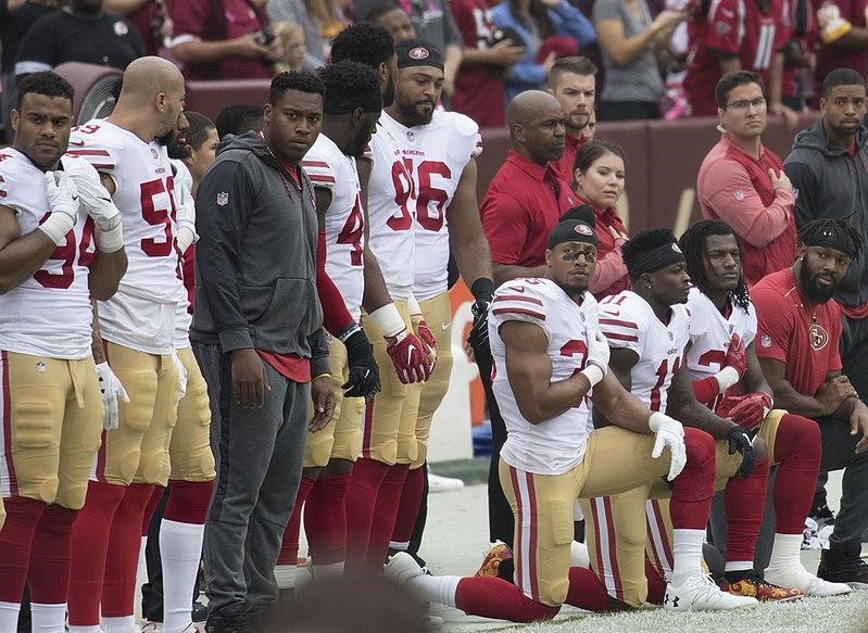 Members of the San Francisco 49ers kneel for the National Anthem before their game on October 15, 2017. Photo via Wikimedia Commons.