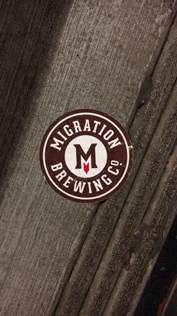 The logo of Migration Brewing, a local company. Many small businesses have been disproportionately affected by minimum wage increases. Photo by Perry Overby.