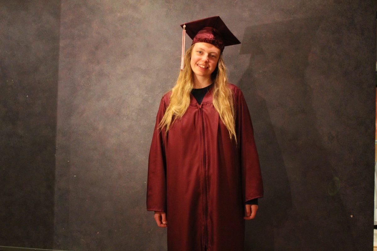 High school senior Lucy Shadburne in her graduation cap and gown. She represents the last class before the cap policy update. Photo by Dannie Blake.