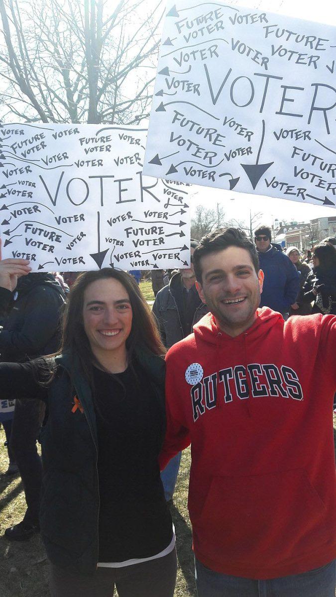 Two protesters of gun violence in New Jersey hold up signs in solidarity with students and future voters.  Photo via Wikimedia Commons.