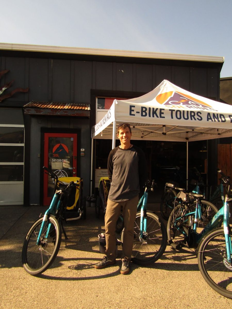 Charlie Crocker, a Wasco County resident, poses in front of his electric bike rental business. Crocker’s business has been hurt by wildfires which have closed bike trails in the area. Photo by 