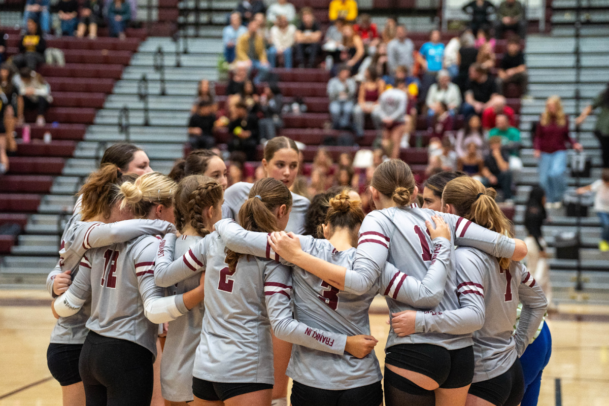 Franklin’s 2024 women’s varsity team huddled together during one of their games. From developing talent and skill to building confidence and determination, Franklin’s volleyball program aims to create an environment that fosters multi-faceted growth in their players. Photo via Tess Martin.