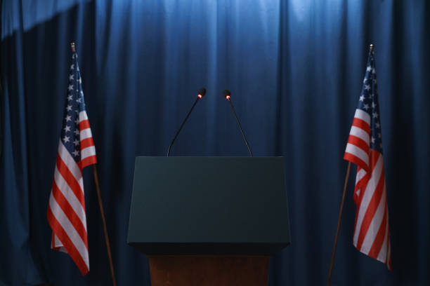 Empty stage before or after the debates with a pedestal and American flags from both sides. Photo by Getty_Images