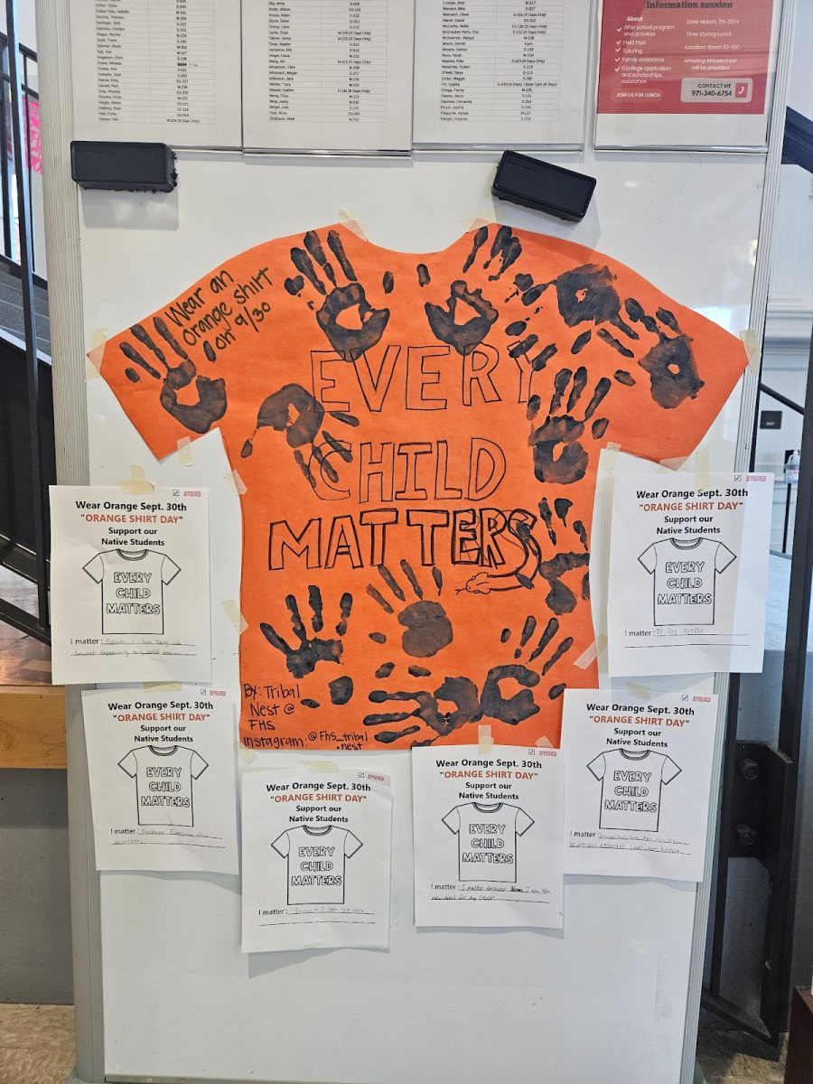 A whiteboard with a cutout of an orange t-shirt with black handprints stating “every child matters.” Sept. 30, is a nationally recognized day to honor, acknowledge, and bring awareness to residential schools in America; on this day everybody is encouraged to wear orange in solidarity. Photo by 