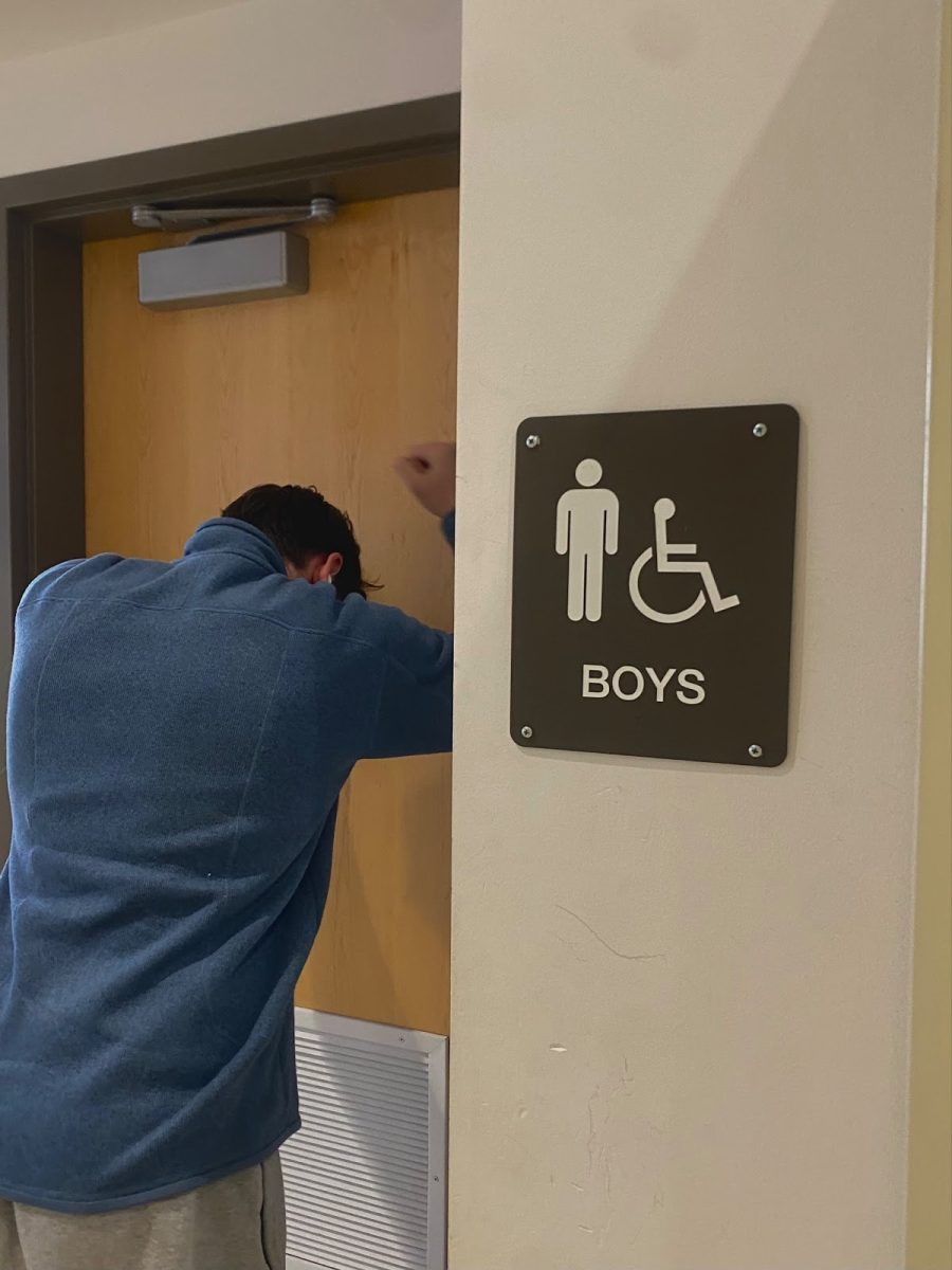 A distressed student at Franklin, unable to access the boys’ bathrooms, which are locked. Recent vandalism to bathrooms at Franklin has caused reactions from students and staff alike. Photo by Emily Robertson.