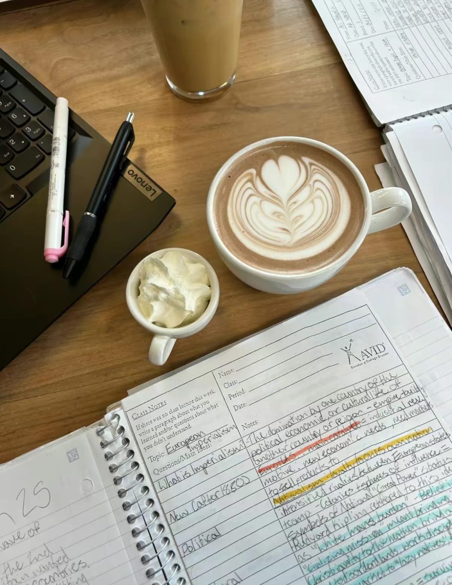 A cup of coffee next to an open notebook in Rain or Shine. Studying in local coffee shops may just be the secret to academic success this school year. Photo by Isa Halle.
