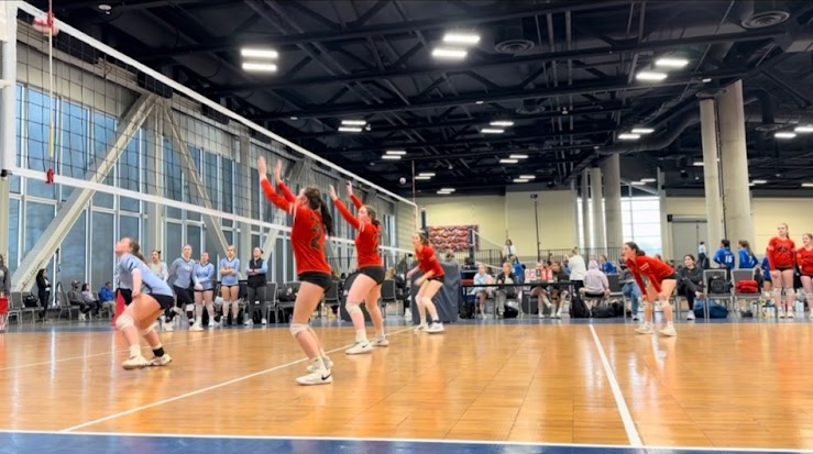 A club volleyball team playing a game at a large, regional tournament. Athletes who choose to play club sports are often required to pay thousands of dollars to participate.