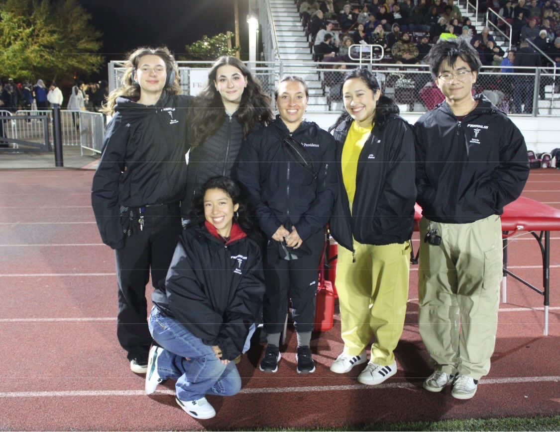 Athletic Trainer Gerilyn Armijo surrounded by students in the sports medicine program at a Franklin home football game. The athletic trainer plays a key role in aiding injured athletes at Franklin. Photo by Jolie Barteaux-Peinado.