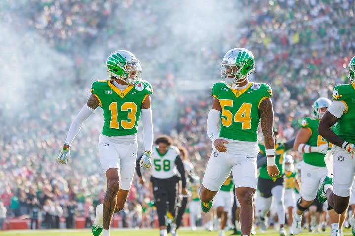 University of Oregon players Sione Laulea and Jerry Mixon running onto the field to play The Ohio State University in this year's Rose Bowl Game. Despite losing the game, the University of Oregon had a record-breaking first season in the Big Ten Conference. Photo by Darby Winter.