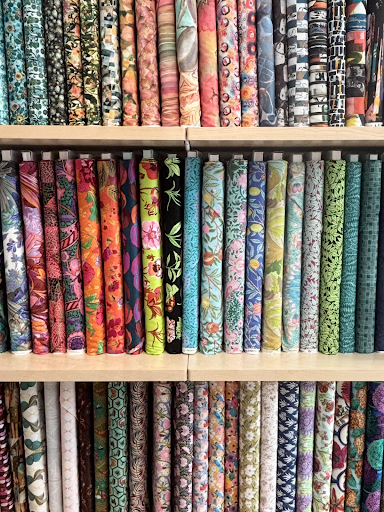 Racks of colorful imported fabrics on display at Bolt Fabric Boutique. Tariffs on imported textiles could drive up costs for shops in Portland and nationwide. Photo by Beatrix Brandau.