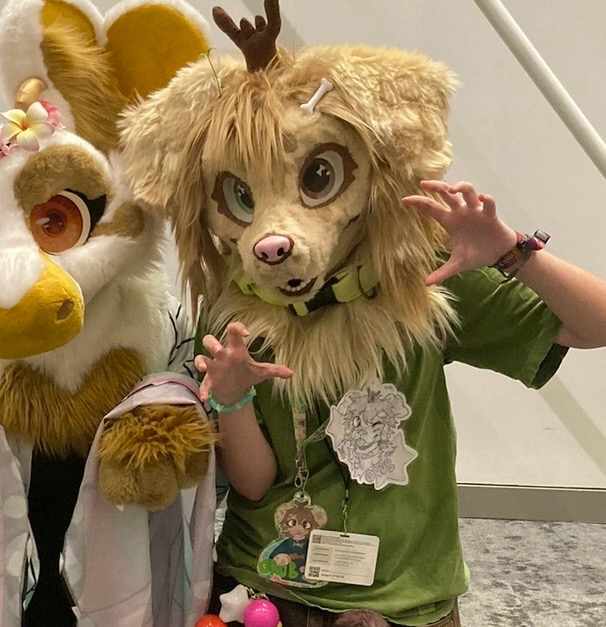 A person posing at a furry convention with a furry head of a dog on. Furries are one of many forms of self-expression often targeted by cringe culture despite being harmless. Photo by @grubthebugdog on Instagram.