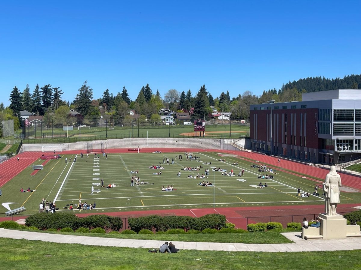 Franklin students spread out across the football field eating lunch in their individual groups. Around campus, many different cliques and social groups with different personalities and values can be found. Photo by 