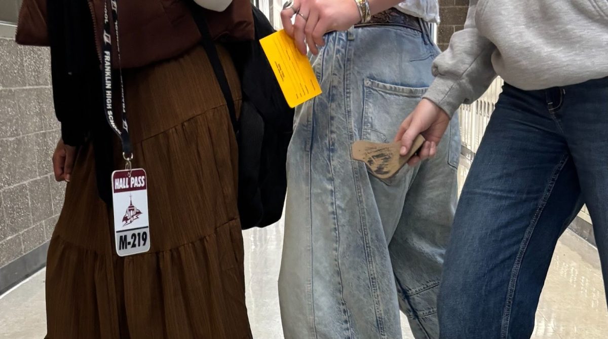 A procession of students carry their hall passes — an original, a paper pass, and a wooden bird — through Franklin. An essential part of student-hood at the school, hall passes can show a range of creativity. Photo by Ramila Ali.