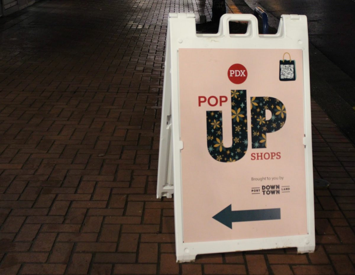 A ground sign in Downtown Portland advertising the seasonal PDX Pop-Up shops, presented by Downtown Portland Clean & Safe. The Pop-Up shops are scattered throughout Downtown, and host a variety of small businesses, giving them the opportunity to reach a larger audience and even find permanent retail space.