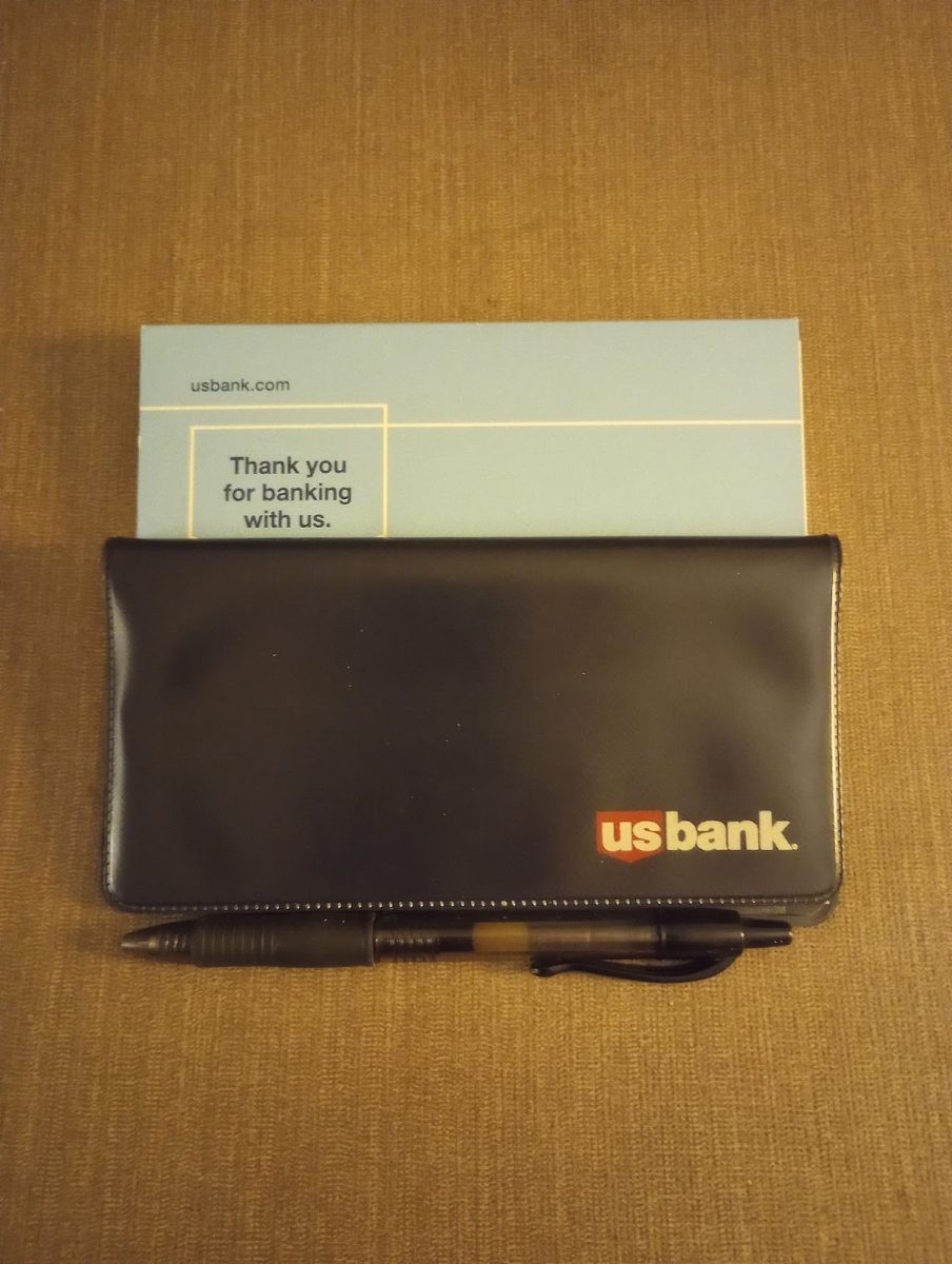 A US Bank check book and pen. Personal finance classes teach students about taxes and banking. Photo by Finn Burton.