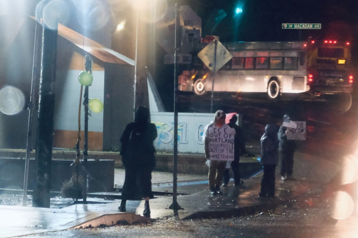Protestors in the rain outside of the Portland Immigration and Customs Enforcement (ICE) facility. Protesting is one of many direct forms of resistance against ICE in Oregon, and many Oregonians are dedicated to making their voices heard rain or shine. Photo by Easton Atlansky.