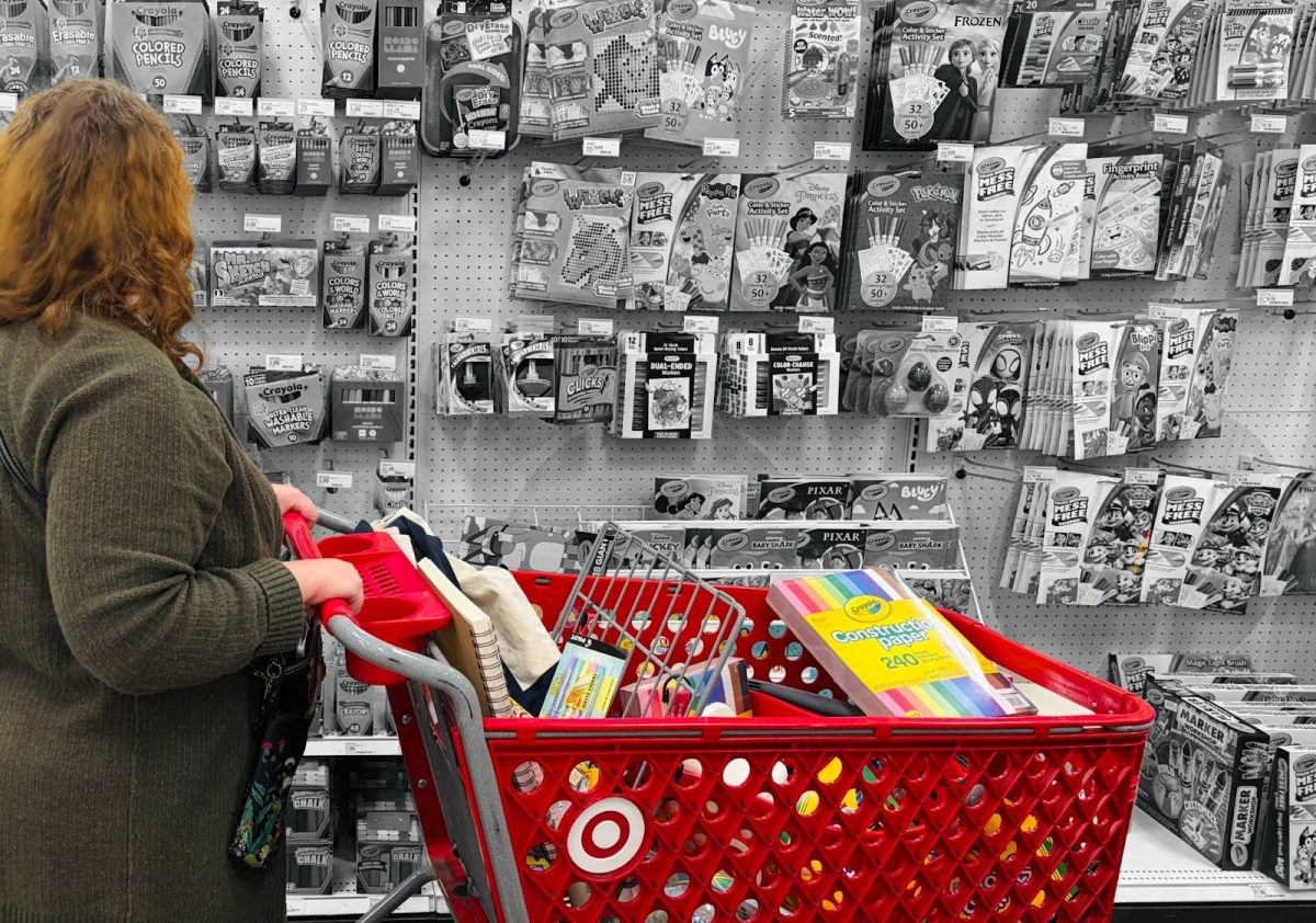 A woman pushes a shopping cart full of school supplies. Teachers spend a lot of their own money on materials for their classrooms and students throughout the school year. Photo by Easton Atlansky.
