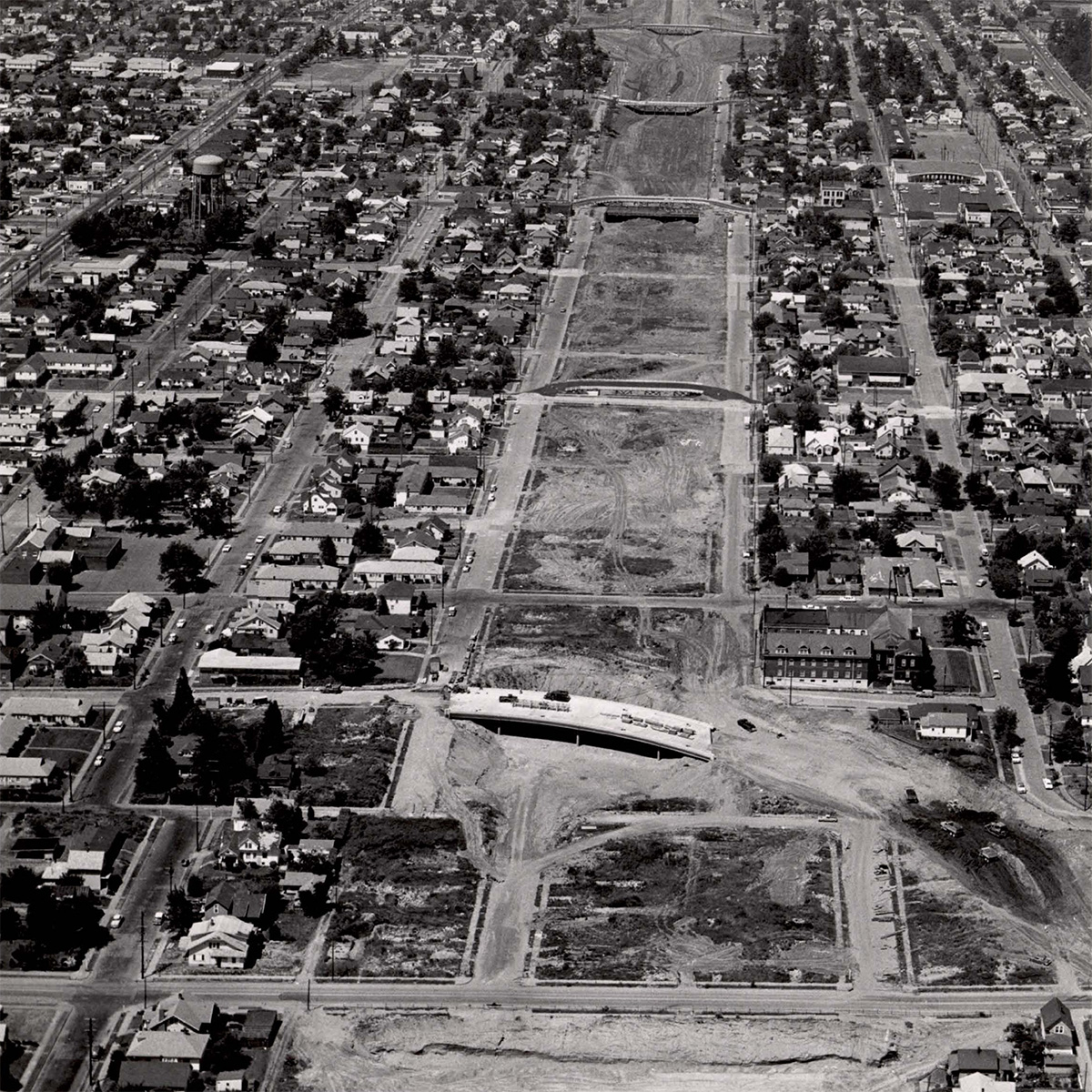 Interstate 5 (I-5) under construction looking north from N Minnesota Ave., 1963. The I-5 development was part of a larger “urban renewal” effort that split the Albina neighborhood in half. Photo via Portland City Archives.