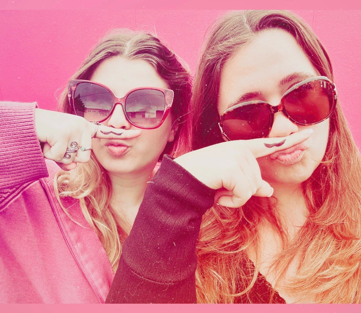 Kate DeWeese and Delilah Semro, fingers mustachioed, pose for a selfie, recreating a trend from the mid-2010s. It’s common among adolescents to engage in nostalgic activities in anticipation of their biggest transition yet: graduating high school. Photo by Kate DeWeese.