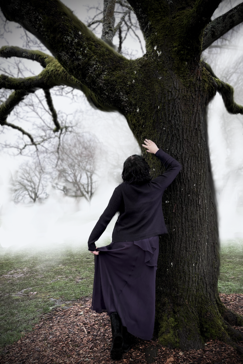 A dark-haired person leans against a tree, portraying Catherine Earnshaw from “Wuthering Heights.” The casting of Catherine Earnshaw as well as the other main character, Heathcliff, is one of many controversies stirred by “Wuthering Heights” (2026). Photo by Rusty MacKenzie.